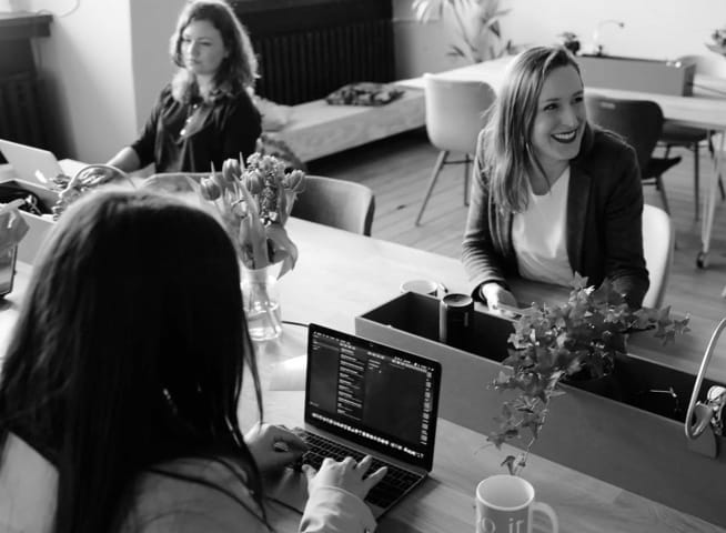 office workers on laptops smiling